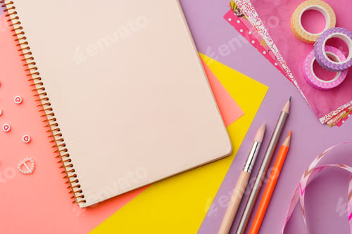 Preview: Scissors and decorative tape on colorful craft paper in a bright workspace