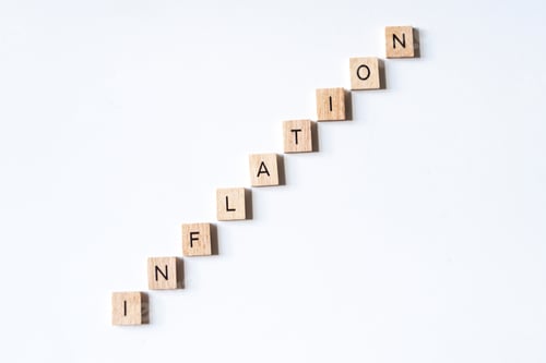 Preview: INFLATION spelled out using wooden letter tiles going up direction on white surface background.
