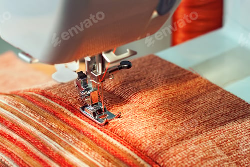 Preview: Sewing machine presser foot and orange fabric. Sewing process