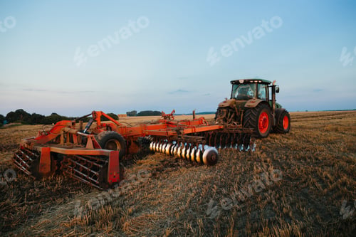 Preview: A tractor with a large disc harrow for tillage. Farmer work concept.