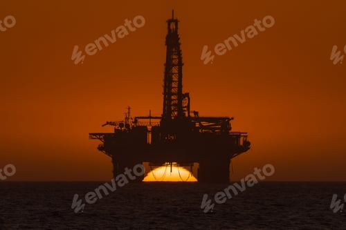 Preview: Sun setting behind oil drilling platform at Longbeach in Namibia