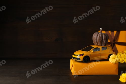 Preview: Toy, yellow car with a gift, pumpkin and flowers, place for text
