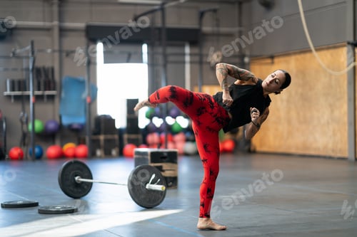 Preview: Woman working out kicking in a cross training gym