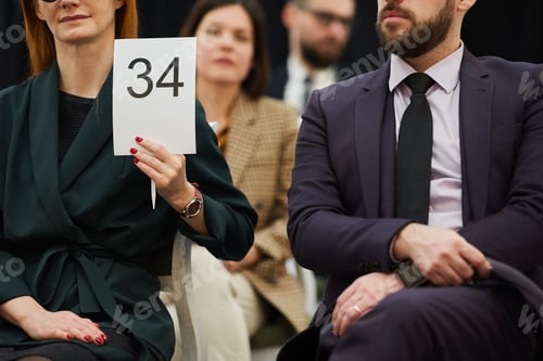 Preview: Woman with sign at auction