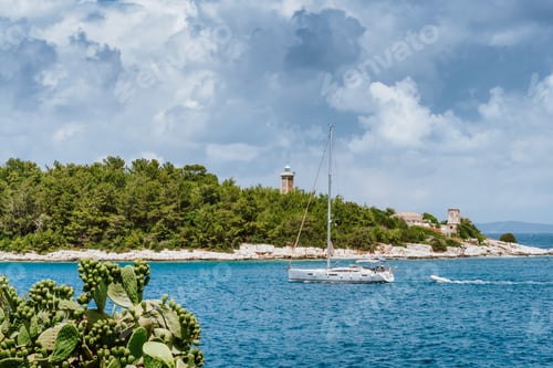 Preview: Summer holiday vacation. Kefalonia island, Greece. White sailing boat approaching port of Fiskardo