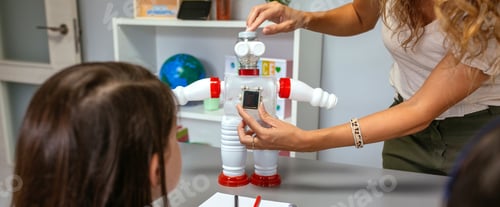 Preview: Teacher in a robotics class explaining how connect solar panel on recycled toy robot