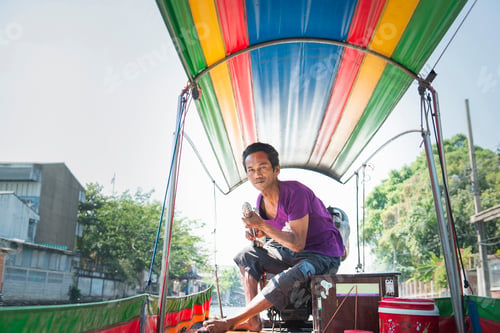 Preview: Tuktuk driver takes a break under the colorful canopy