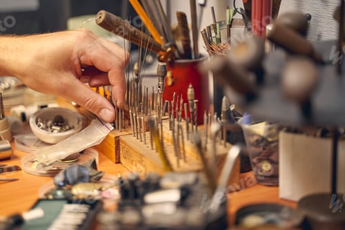 Preview: Male hand choosing a bur among the toolkit