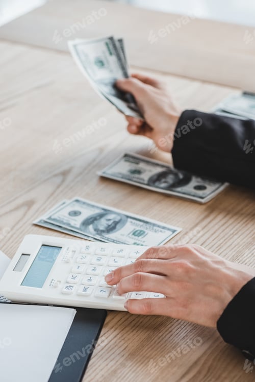 Preview: cropped image of business adviser calculating dollars in office