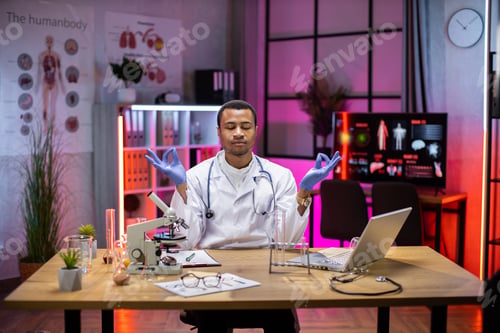 Preview: Yong african american male scientist relaxing practicing yoga wearing lab coat working in laboratory
