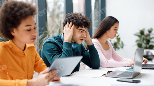 Preview: Worried sad student guy looking at laptop, getting final test results, sitting with groupmates in