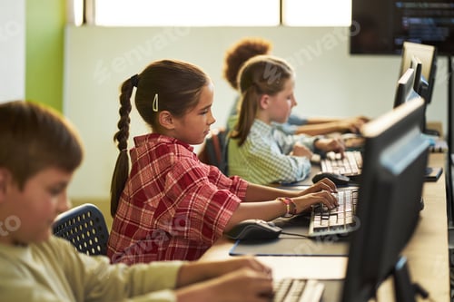 Preview: Preteen Caucasian Girl Typing on Computer Keyboard in Classroom Setting