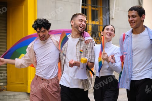 Preview: Young friends celebrating pride with rainbow flags during parade
