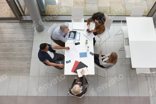 Preview: Overhead view of business team having meeting at conference table