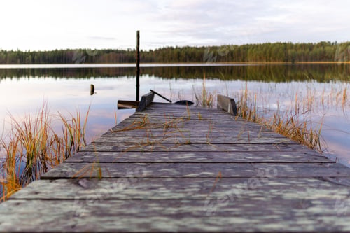 Preview: Weathered dock surrounded by the tranquil waters of a lake.