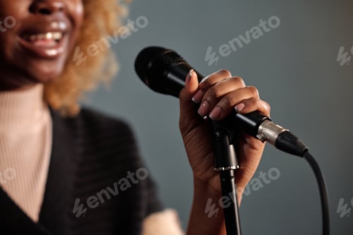 Preview: Hand of young comedian with microphone