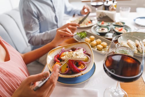 Preview: Young woman and man having lunch in restaurant