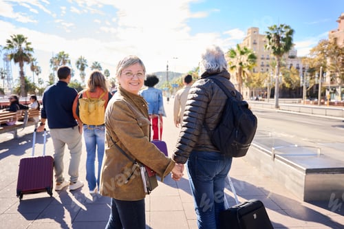 Preview: Happy husband and wife walking of the streets of the city on holidays. Mature tourist couple