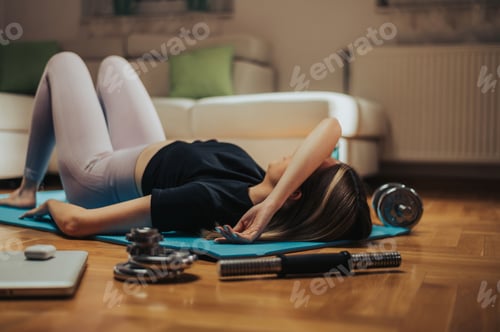Preview: Attractive young woman lying on the floor exhausted after her training