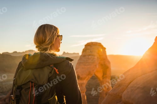 Preview: Explorer taking in the serene view of a desert landscape at sunset
