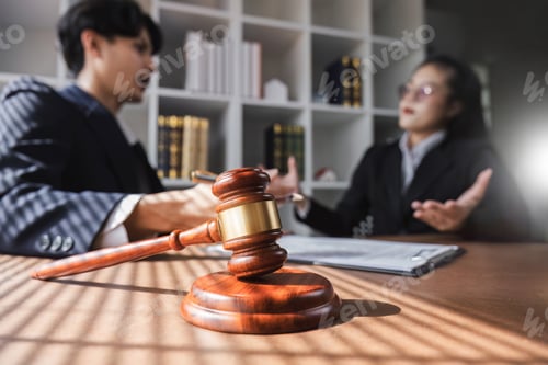 Preview: Businessman and lawyer discussing business contract document for legal advice in lawyer's office.