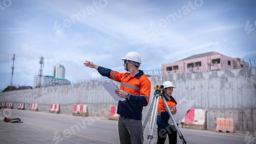 Preview: Engineers Surveyor wearing safety uniform ,helmet with equipment theodolite to measurement positioni