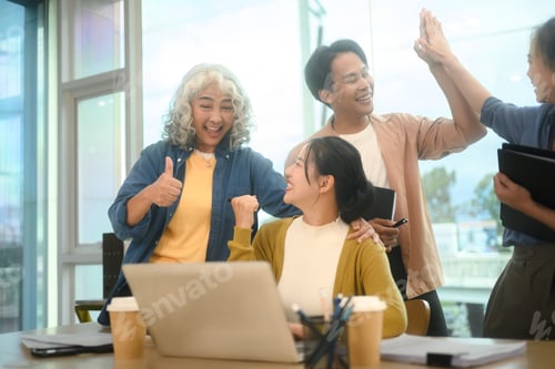 Preview: Group of business professionals celebrating their successful project in the office