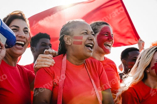 Preview: Multiracial red sport football fans celebrate team victory in championship soccer game at stadium