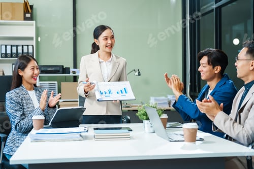 Preview: In a boardroom, an Asian team meets at a desk, presenting financial terms and strategies.