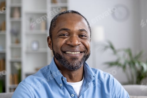 Preview: Close-up portrait of mature experienced African American man smiling and looking at camera while