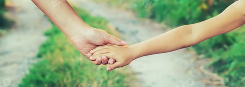 Preview: mother and child go by the hand. Selective focus.