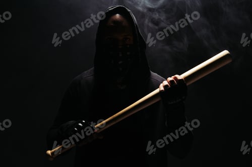 Preview: Silhouette of african american man in hoodie and gloves holding baseball bat on black background