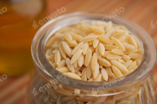 Preview: Orzo pasta sits in a glass jar on a wooden surface
