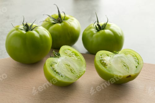 Preview: Whole and half green unripe tomatoes