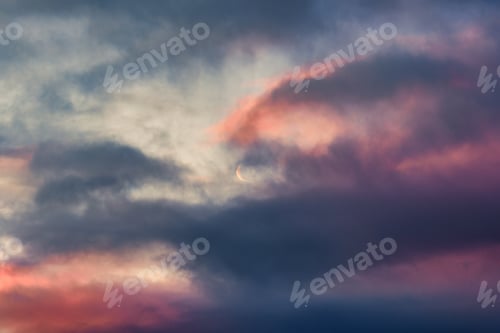 Preview: Evening sky with moody clouds and crescent moon