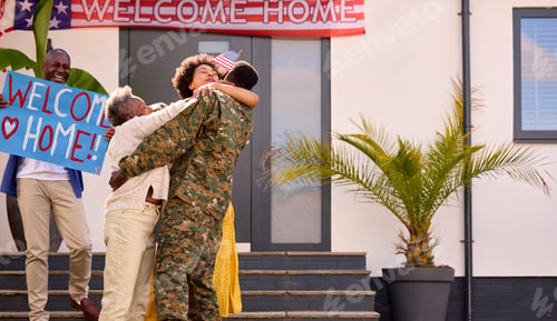 Preview: Multi-Generation Family With Parents And Wife Welcoming Army Soldier Home On Leave With Banner