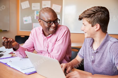 Preview: High School Tutor Giving Male Student One To One Tuition At Desk