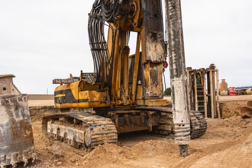 Preview: large heavy machine drilling dirt on a construction site near an open area