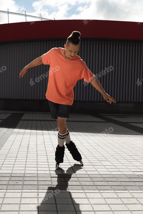 Preview: Young man in roller skates riding on urban street at daytime