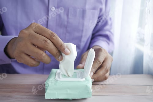 Vista previa: hand pick cleansing wet wipes on table with copy space