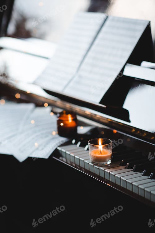 Preview: Piano keys with burning candles close up