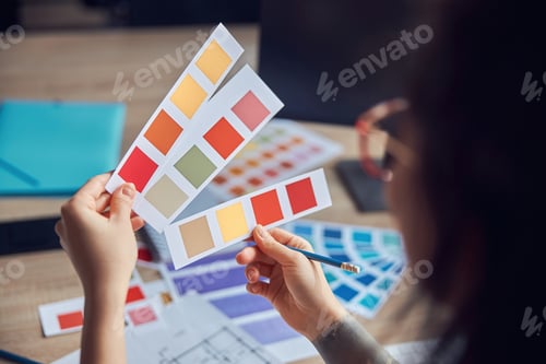 Preview: Close up shot of hands interior designer holding color samples while working on a project
