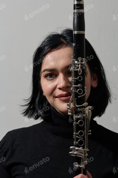 Preview: Graceful Brunette Musician Posing with Clarinet on White Background