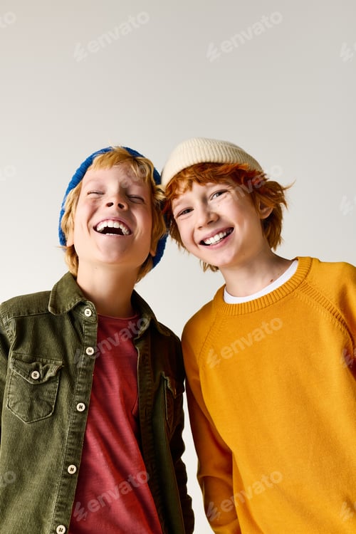 Preview: Two joyful boys sharing laughter in stylish hats during childhood moments