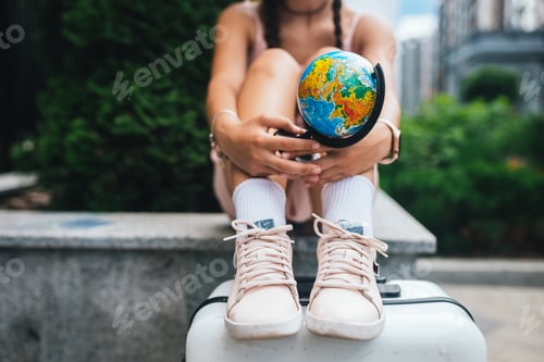 Preview: Cropped photo. Beautiful young woman holds a small globe