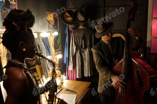 Preview: Young Black Woman Playing Saxophone with Middle Aged Caucasian Man Performing Bass