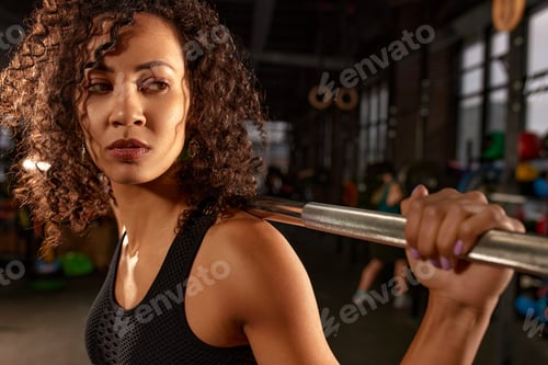 Preview: Sporty african american woman pumping up muscles with barbell, crossfit, weightlifting or deadlift