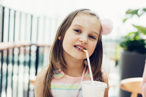 Preview: Young girl drinking soft drink in fast food restaurant