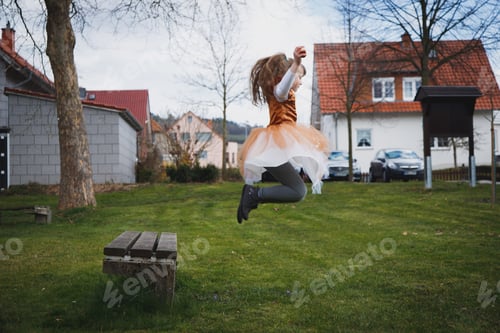Preview: A girl is jumping from a bench in the park.