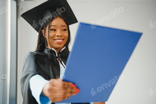 Preview: African American graduate holding diploma.